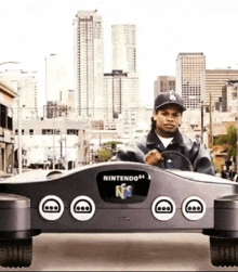 a man is driving a car made out of a nintendo 64 video game controller .