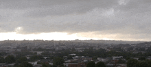 a cityscape with a cloudy sky and a few buildings