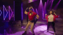 a man in a superhero costume is dancing with a woman in a red jacket .