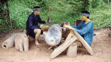 a man in a blue shirt is sitting next to another man in a blue shirt