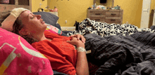 a woman laying on a bed with a bandage on her forehead