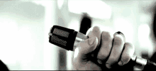 a person is holding a microphone with a ring on their finger