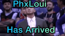 a man in a suit and tie stands in front of a crowd with the words phxloui has arrived