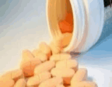 a bottle of pills is pouring out of it onto a pile of pills .