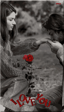 a black and white photo of a man kissing a woman 's hand with the words " i love you " in red