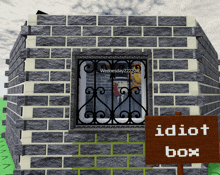 a brick building with a sign that says idiot box in front of it