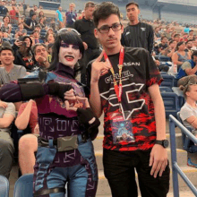 a man and a woman are posing for a picture in front of a crowd of people .