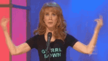 a woman giving the middle finger while wearing a shirt that says g ' rrl town