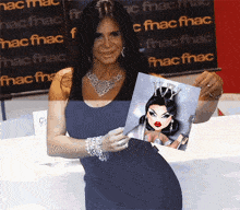 a woman in a black dress is holding a picture of a drag queen