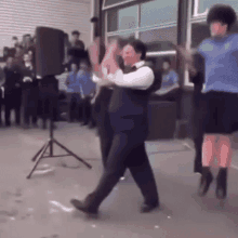 a group of people are dancing in a room with a speaker in the background