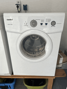 a white comfee dryer is sitting on a wooden table