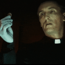 a priest is holding a coin in his left hand