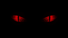 a close up of a pair of red eyes in the dark