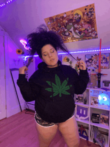 a woman in a hoodie with a marijuana leaf on it