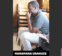 a man sitting in a chair with the name maramara urakuze written below him