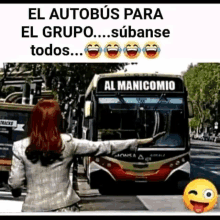 a woman is standing in front of a bus that says al manicomio on the front of it .