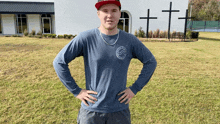 a man with his hands on his hips stands in front of a white building