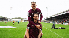 two soccer players are celebrating a goal on a field