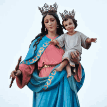 a statue of a woman holding a child with crowns on his head