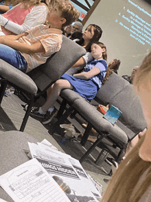 a group of children are sitting in a church watching a presentation about wings hidden