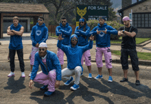 a group of men standing in front of a sign that says for sale