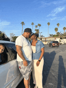 a man and a woman kissing in a parking lot