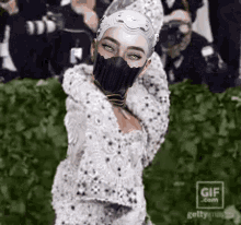 a gif of a woman wearing a mask with a gif.com logo in the corner