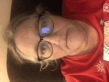 an older woman wearing glasses and a red shirt