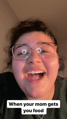 a woman wearing glasses is smiling with the caption " when your mom gets you food "