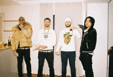 a man wearing a white casablanca paris sweatshirt stands with two other men