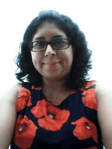 a woman wearing glasses and a red and black floral shirt