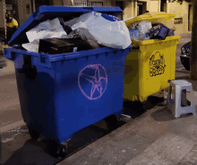 a blue trash can has a pink star painted on the side