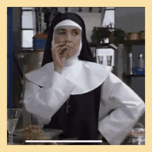 a nun smoking a cigarette in a kitchen with a cross on her collar