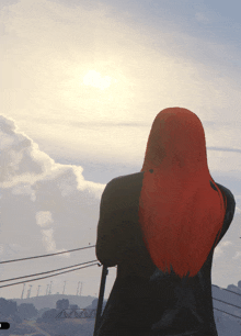 a person with red hair is looking at the sun