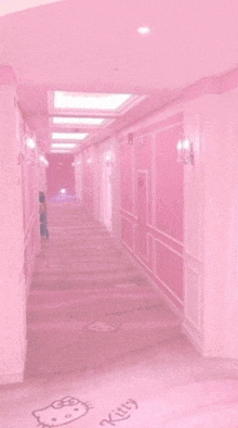 a hallway with pink walls and a hello kitty drawing on the floor .