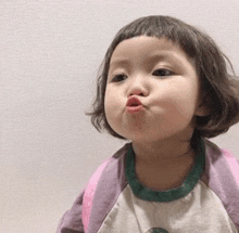 a little girl with short hair is making a face .