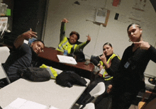 a group of people posing for a picture with one wearing a yellow vest