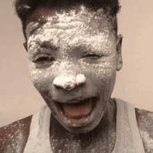 a person with white powder on their face is making a funny face