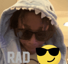 a person wearing sunglasses and a shark hood has rad written on the bottom