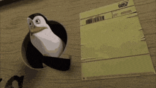 a penguin is sticking its head out of a hole next to a piece of paper with the number 6857 on it