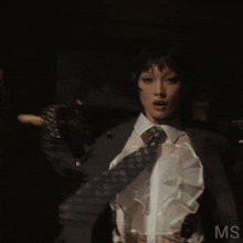 a woman in a suit and tie has the letters ms on the bottom