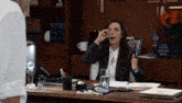 a woman sitting at a desk with a glass of water in front of a plaque that says ' attorney ' on it