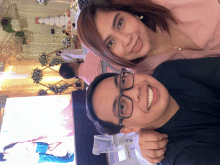 a man and a woman are posing for a picture with a wedding cake in the background