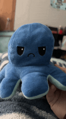 a blue stuffed octopus with a sad face