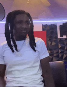 a man with dreadlocks is wearing a white t-shirt that says ' snoop dogg ' on it