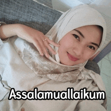 a woman wearing a hijab is laying on a couch with the words assalamualaikum written on the bottom