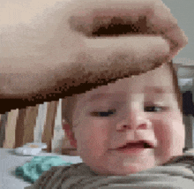 a pixelated image of a baby being held by a person