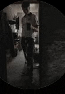 a blurry picture of a man standing in a dark room holding a cup .