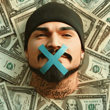 a man with a tattoo on his neck has his mouth taped with a blue tape