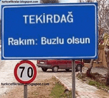 a blue sign that says tekirdag on it with a red car in the background